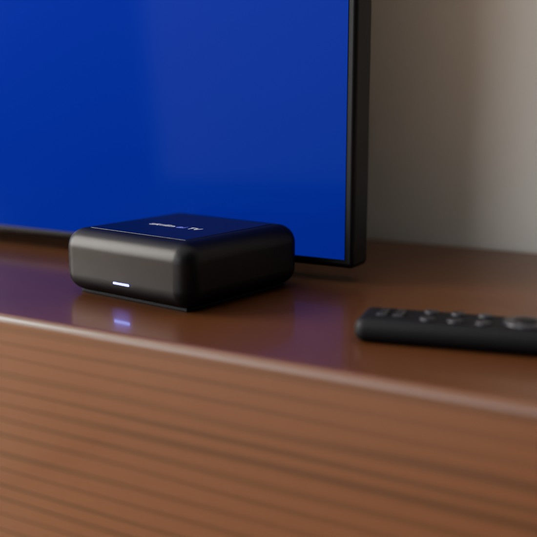 The skriin ai TV box and the short remote on a walnut console